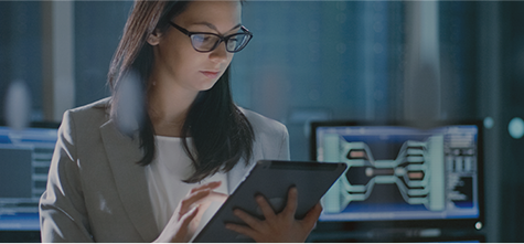 Female cybersecurity professional looking at information on a handheld tablet